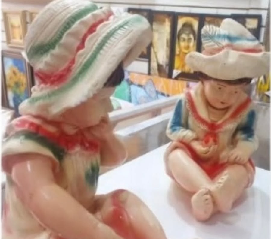 Par de crianças em gesso antes da restauração